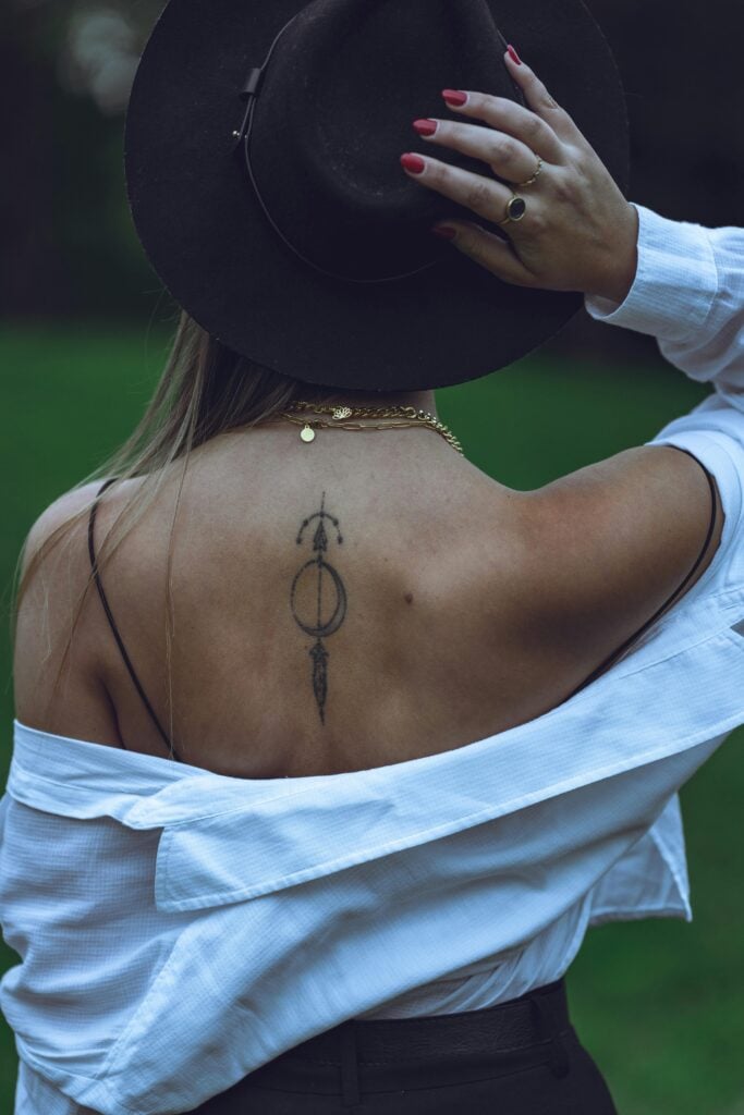 Back view of a woman in Bayreuth, showcasing a tattoo and fashion style in nature.